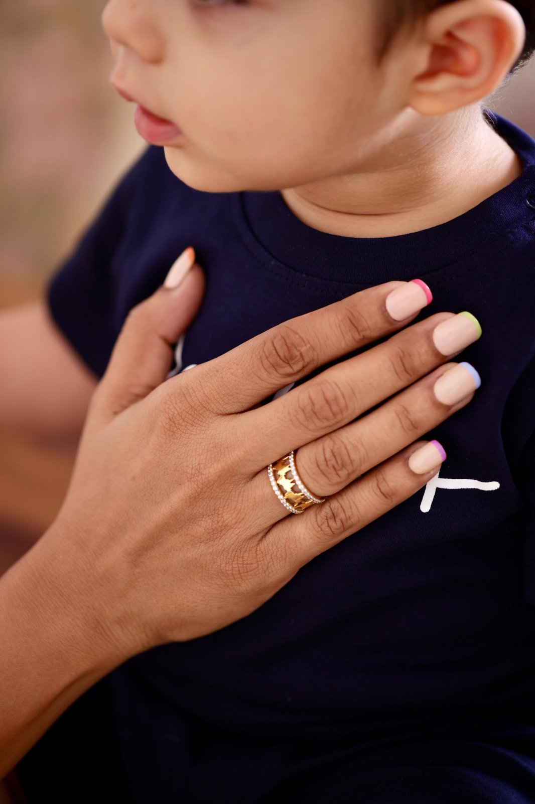 Gold Vermeil ring worn on a mother's hand, showcasing the heartbeat waveform Gold Vermeil ring held close-up, highlighting the detailed craftsmanship of the heartbeat waveform design and shimmering dimonds as a meaningful keepsake